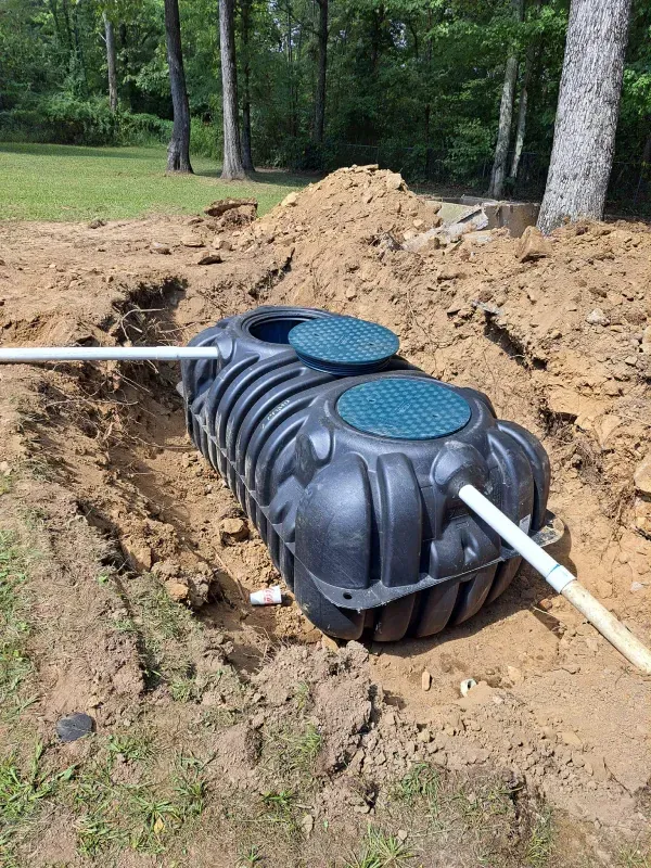 A septic tank is sitting in the middle of a dirt field.