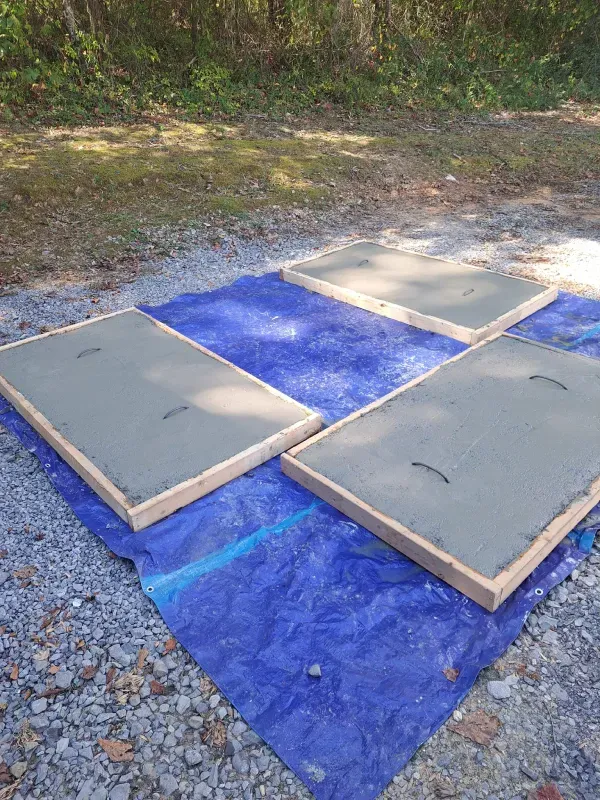 Four concrete slabs are sitting on top of a blue tarp.