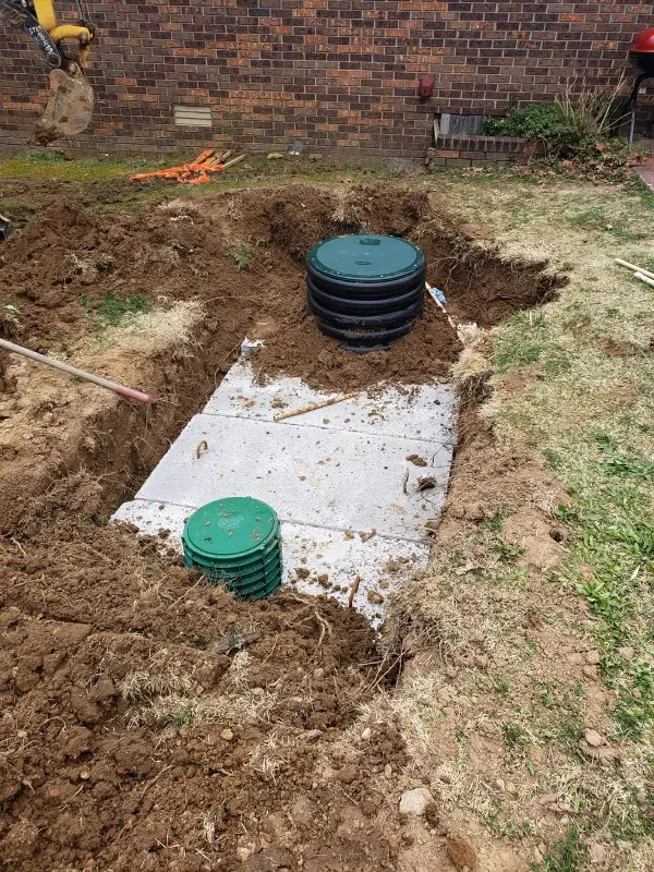 A septic tank is being installed in a backyard.
