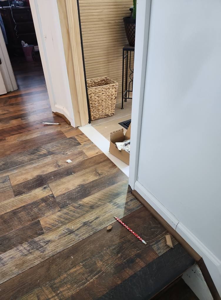 Installation in progress. A pencil and flooring debris on the floor, near an unfinished doorway.