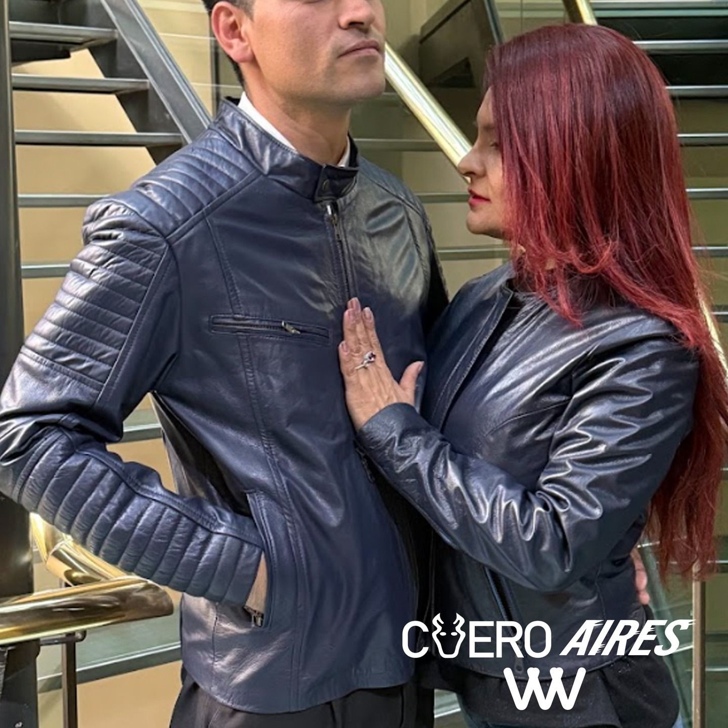 Pareja con chaquetas de cuero cerca de una escalera. 