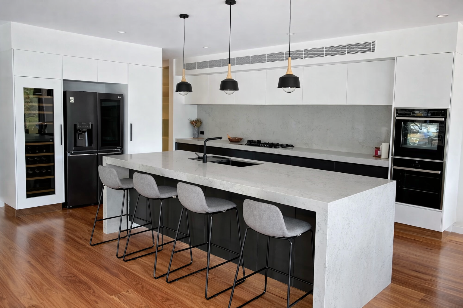 White Kitchen with Stainless Steel Appliances, Grey Countertops, and Wood-Look Flooring — Paul Tagget Kitchens In Goonellabah, NSW