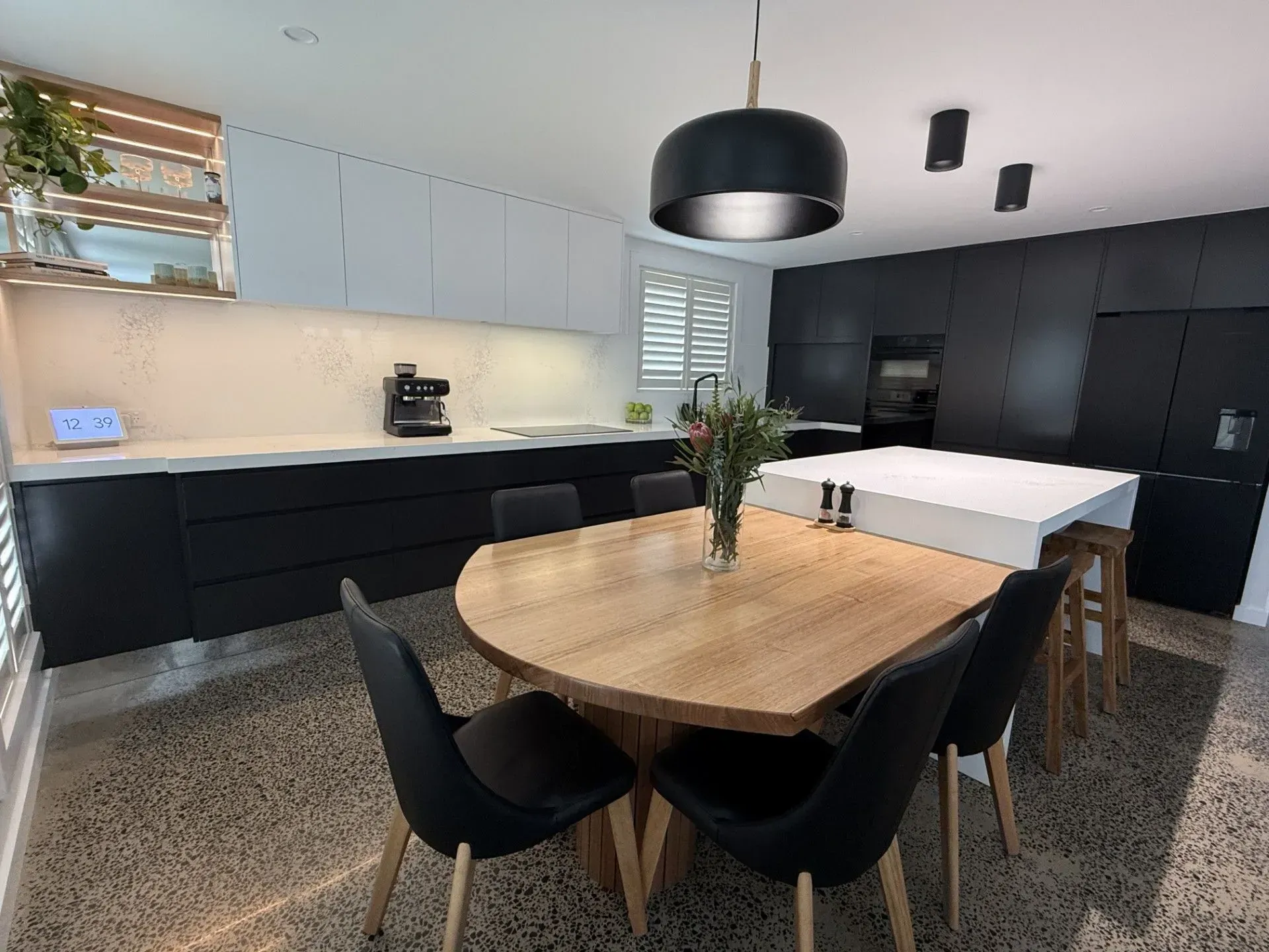 Modern Kitchen With Black and White Cabinetry, a Wooden Dining Table, and Six Black Chairs — Paul Tagget Kitchens In Goonellabah, NSW
 
