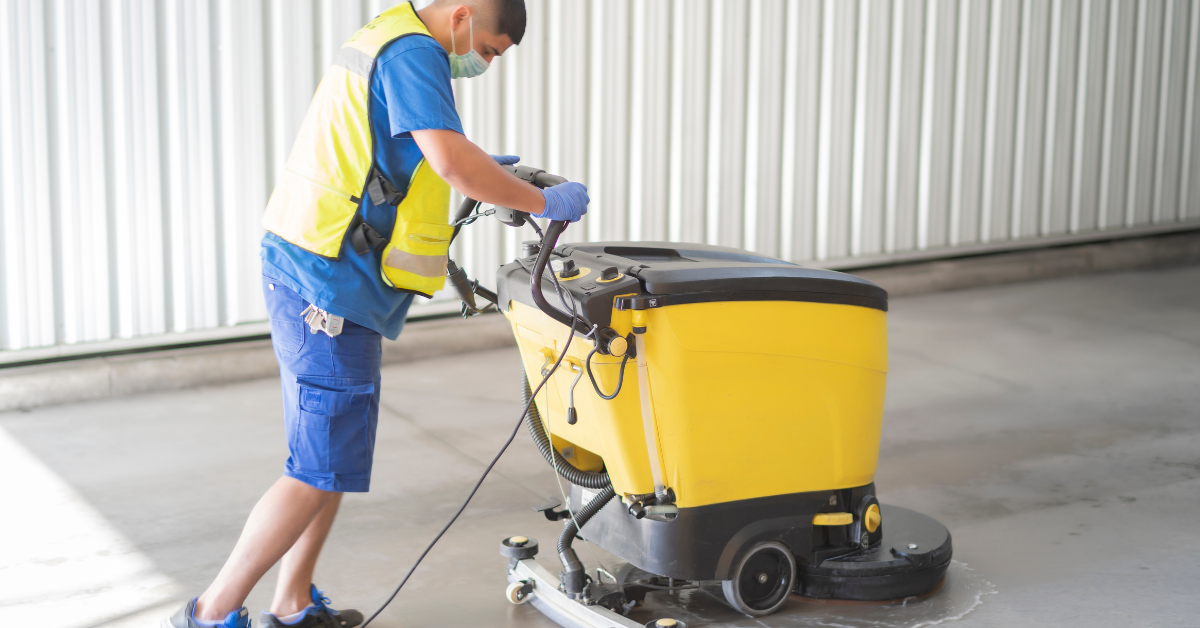 Professional man cleaning floor with machine