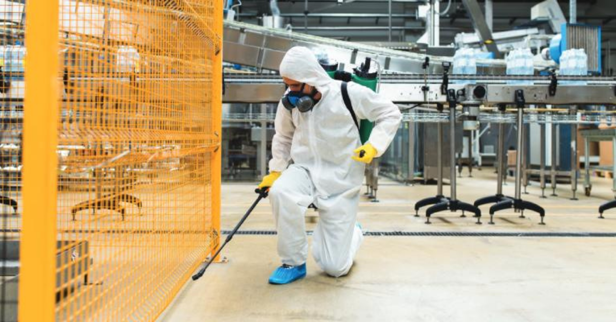 professional man spraying cleaning products in a food factory