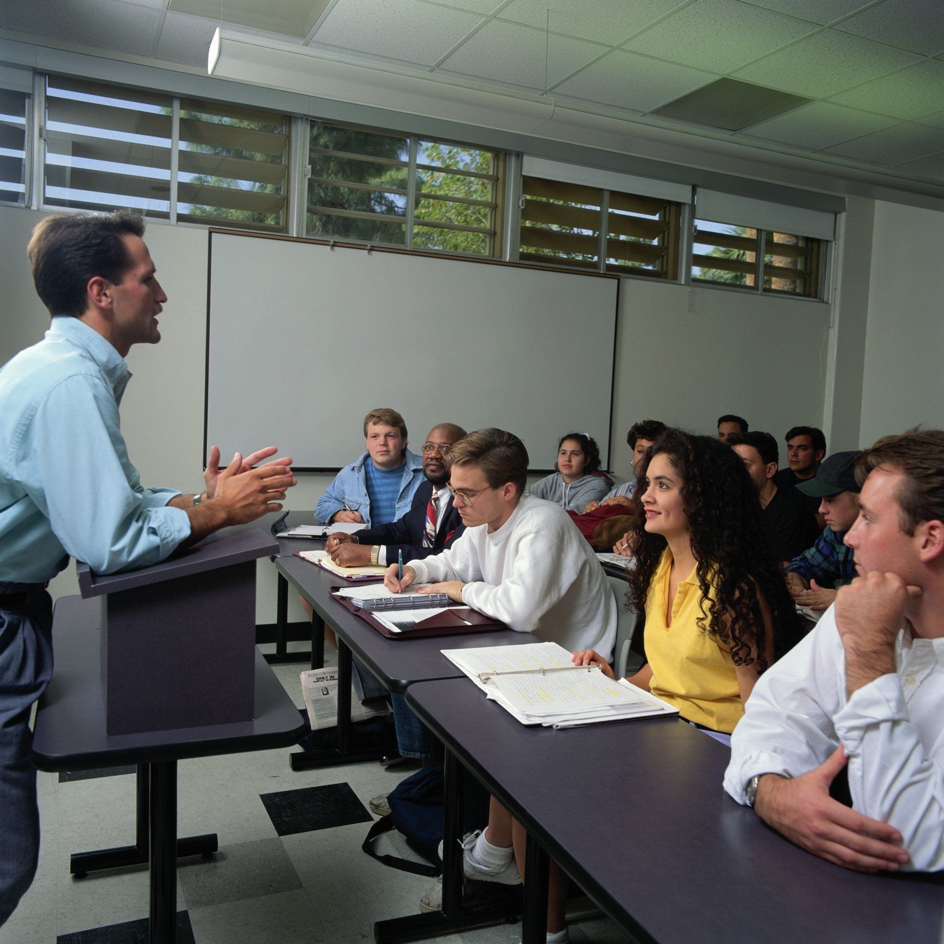 A man is giving a lecture to a group of students