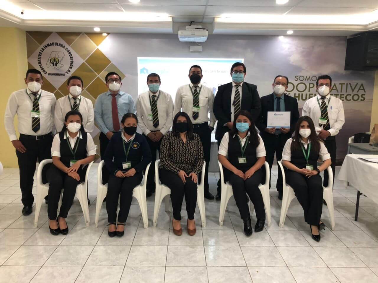 Grupo de personas posando para una foto en una oficina. Visten ropa profesional.