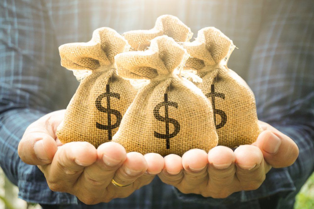 Hands Holding Three Burlap Sacks — Freedom Wealth Solutions In Mornington, VIC