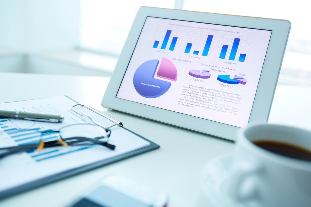 Tablet Displaying Graphs and Charts on A Desk with A Clipboard — Freedom Wealth Solutions In Mornington, VIC