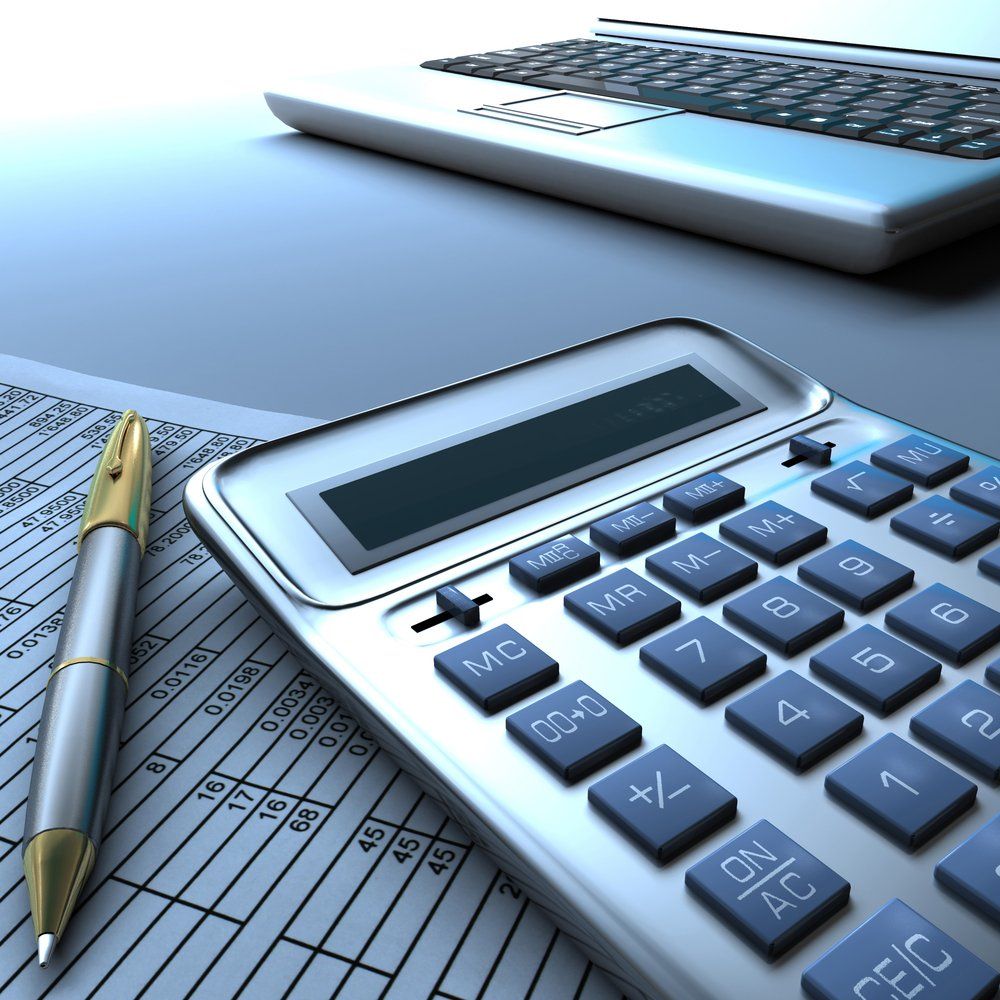 Calculator, Pen and Laptop on A Desk — Freedom Wealth Solutions In Mornington, VIC
