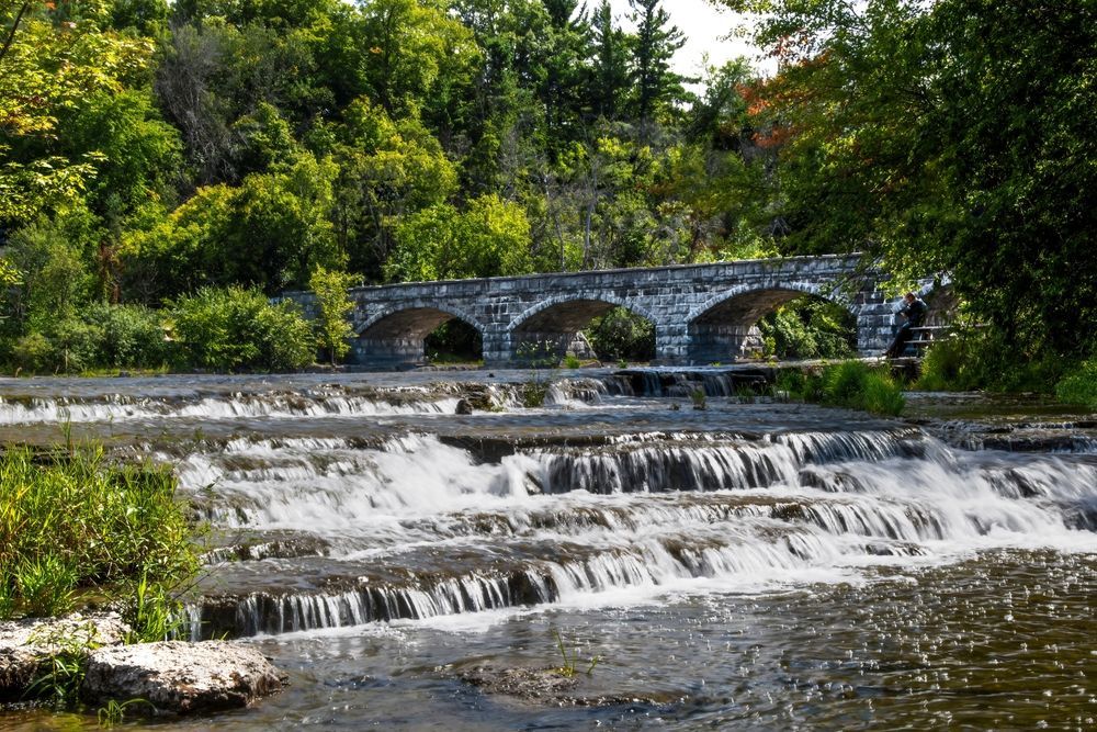 Stone Bridge Arches Over Tiered Waterfall — Freedom Wealth Solutions In Pakenham, VIC