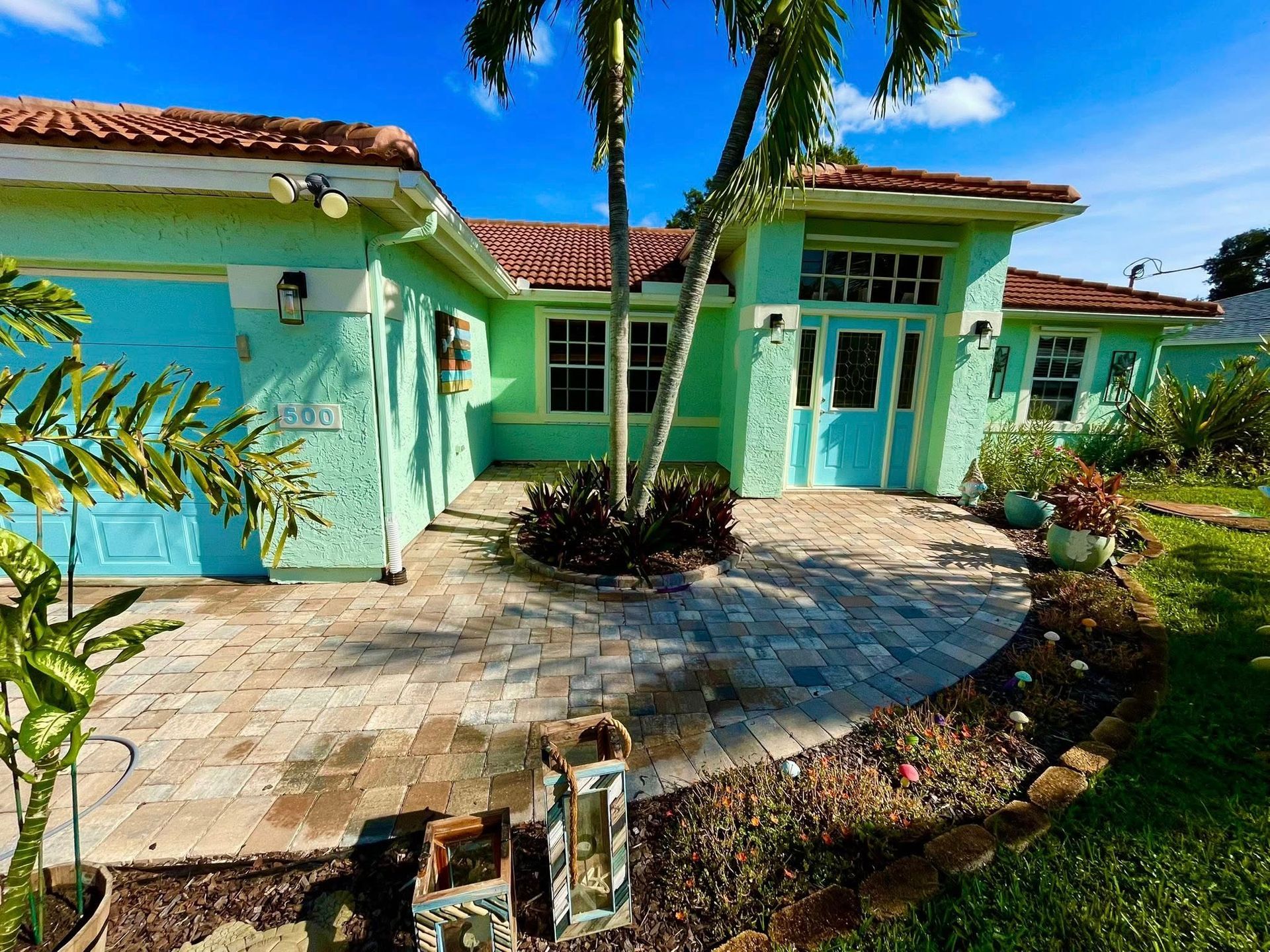Woman in straw hat smiles, holding wine glass near a lake.