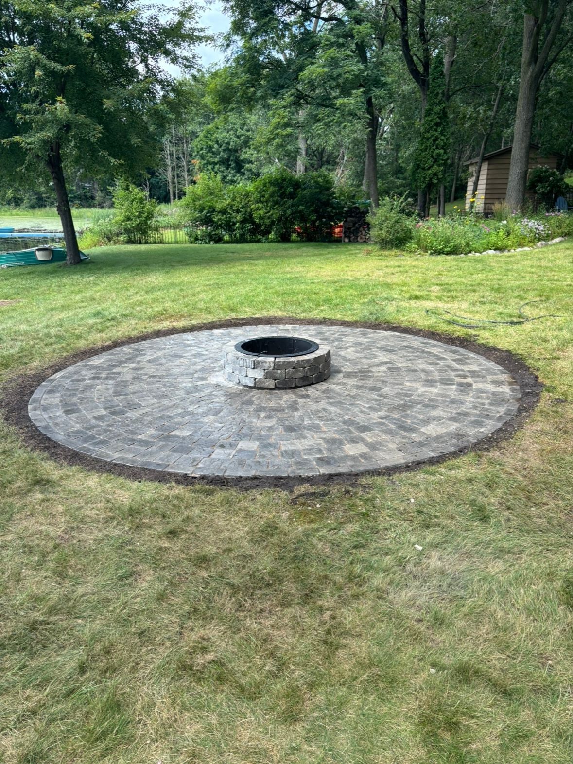 A fire pit is sitting in the middle of a lush green field.