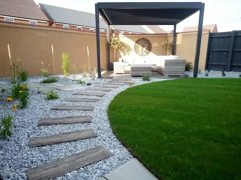 A backyard with a pergola and a couch in it.