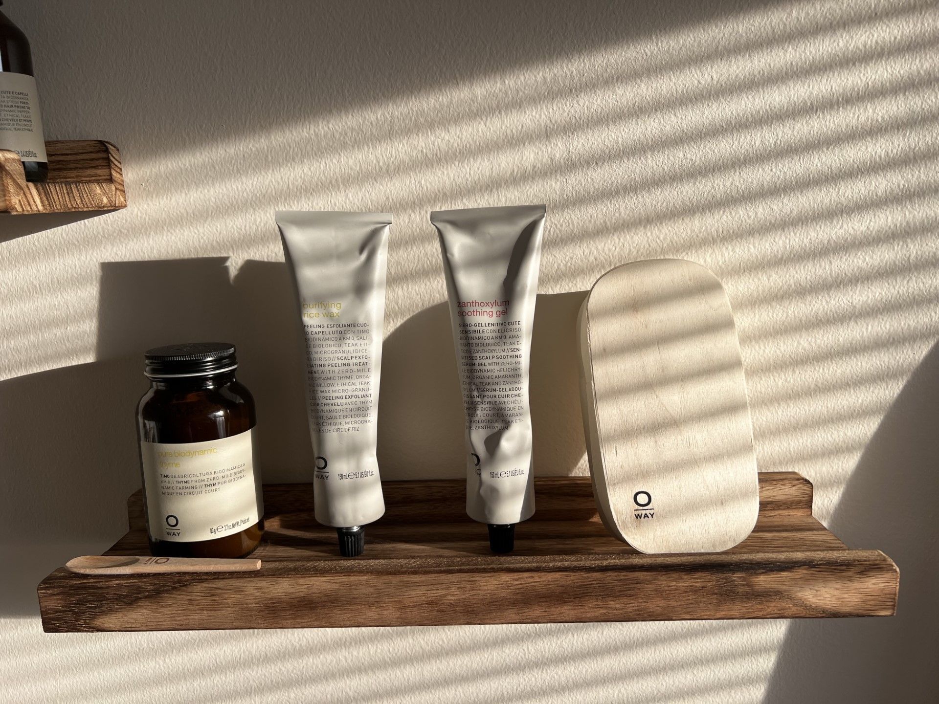 Three tubes of lotion are sitting on a wooden shelf — St. Charles, IL — Studio Genesis - Hair Loss Solutions