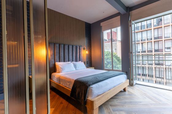 A bedroom with a large bed and a large window.