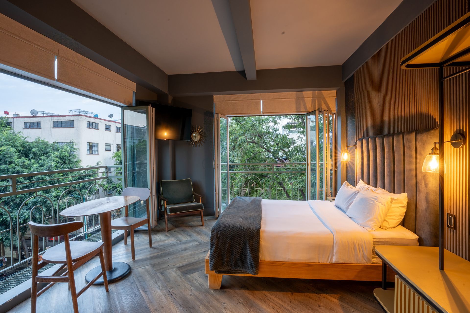 A hotel room with a king size bed , table and chairs.