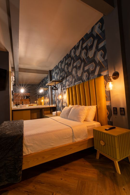 A hotel room with a large bed and a nightstand.