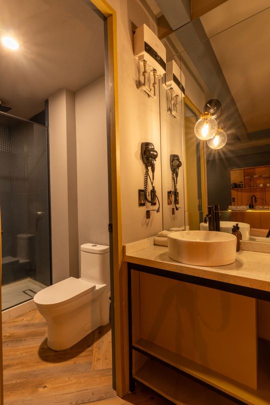 A bathroom with a toilet , sink and mirror.