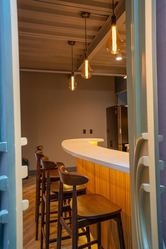 A row of bar stools sitting next to a counter in a room.