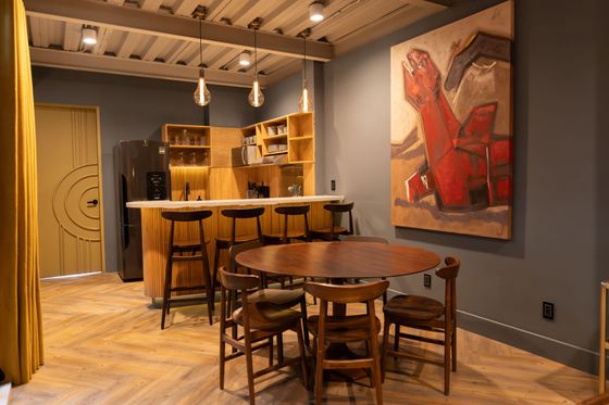A kitchen with a table and chairs and a painting on the wall.