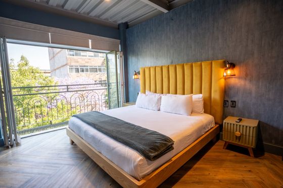 A hotel room with a king size bed and a balcony.