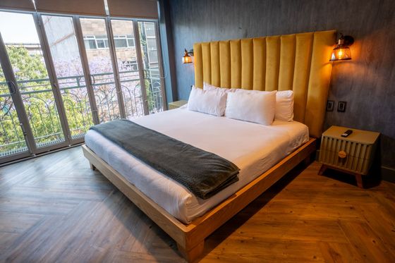 A hotel room with a king size bed and a large window.