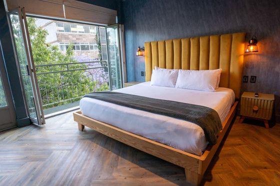 A hotel room with a king size bed and a balcony.