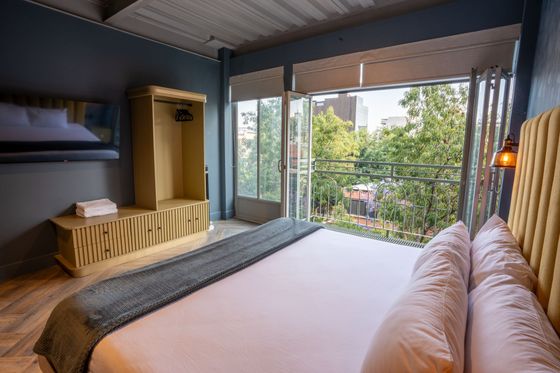 A hotel room with a large bed and a balcony.