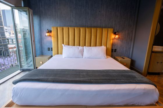 A hotel room with a king size bed and a large window.