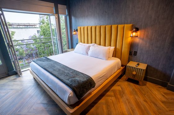 A hotel room with a large bed and a balcony.