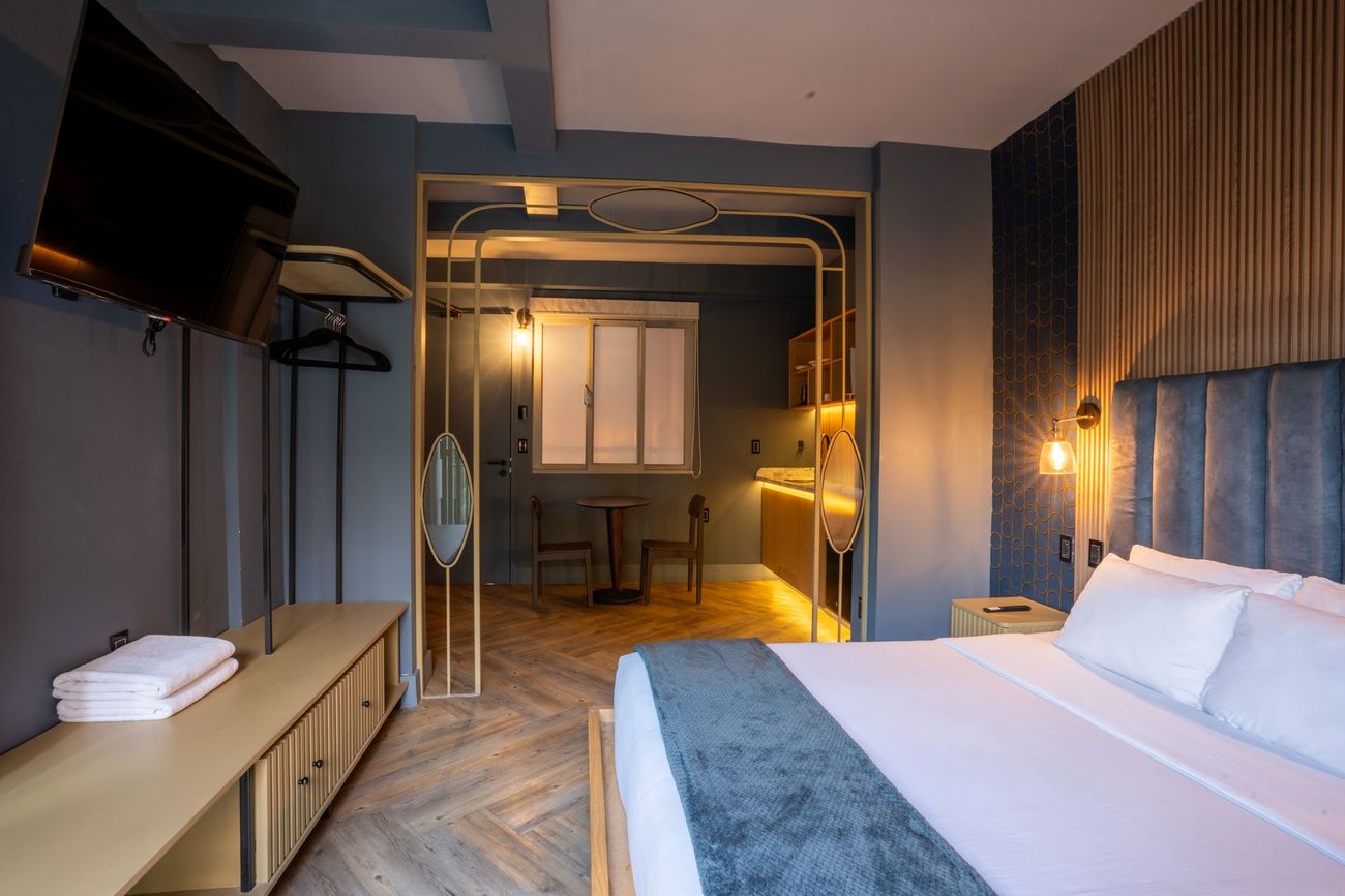 A hotel room with a king size bed , a television , a table and chairs.