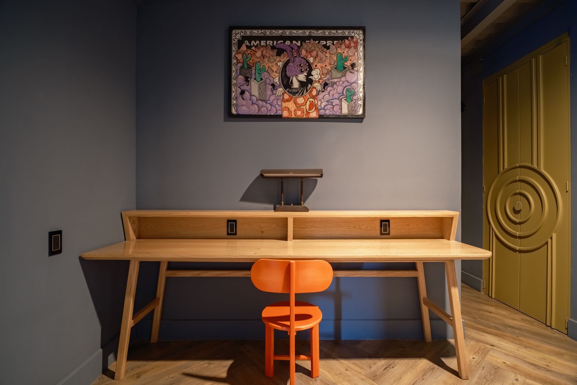 A kitchen with a bar and stools and a refrigerator.