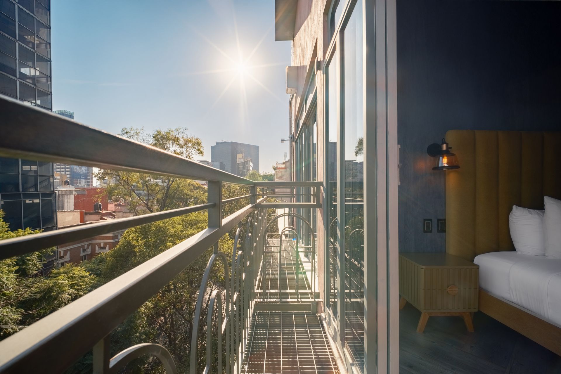 A balcony with a fire escape and trees in the background.