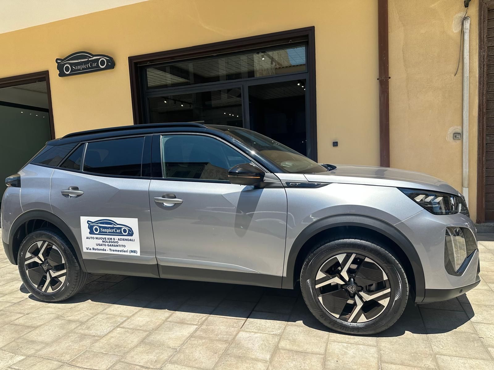Un'auto argentata è parcheggiata davanti a un edificio.