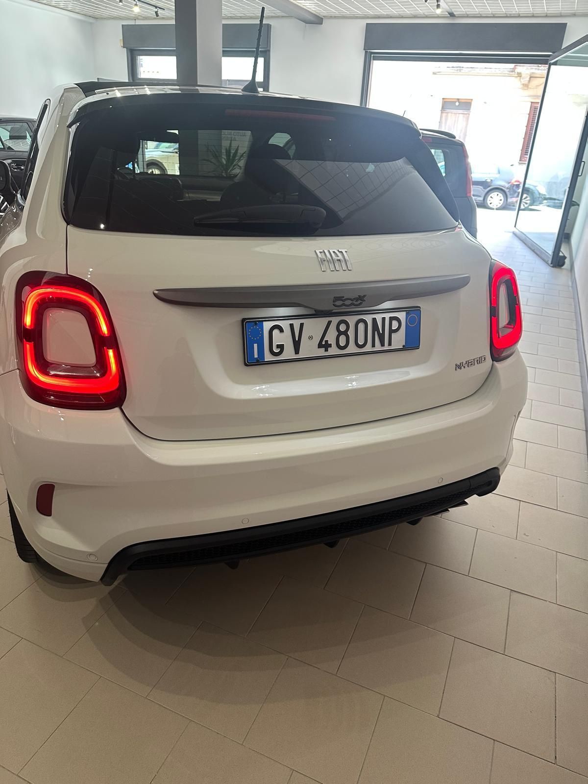 Un'auto bianca è parcheggiata in un garage con una targa che riporta gv 480np.