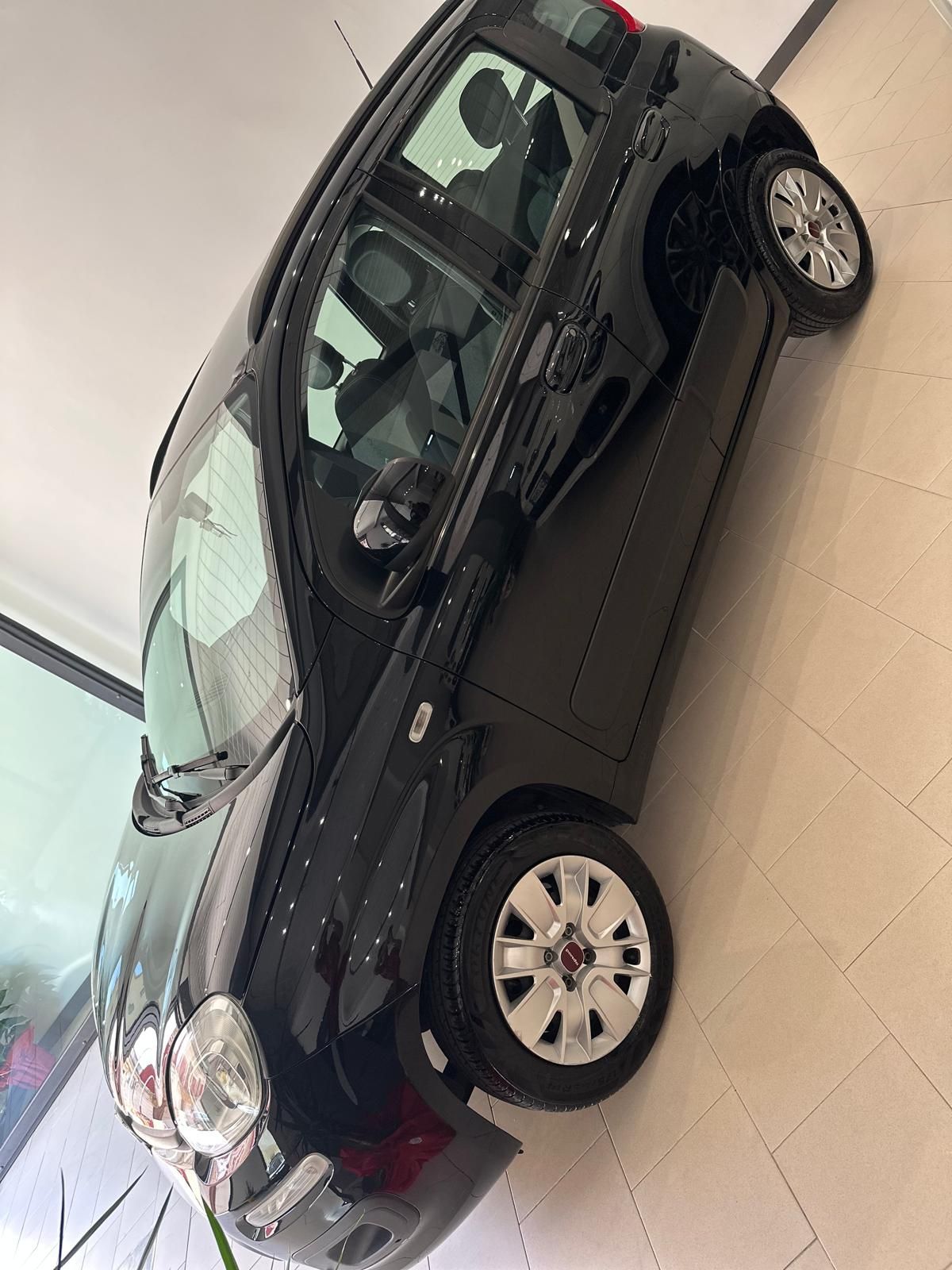 Un'auto nera è parcheggiata sul pavimento di uno showroom.