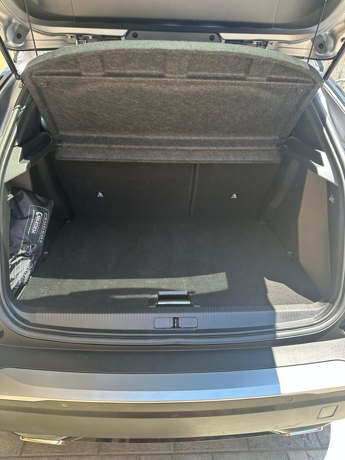 Il bagagliaio di un'auto è aperto e vuoto.