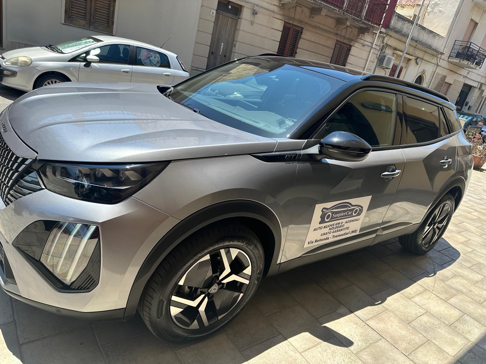 Un'auto argentata è parcheggiata davanti a un edificio.