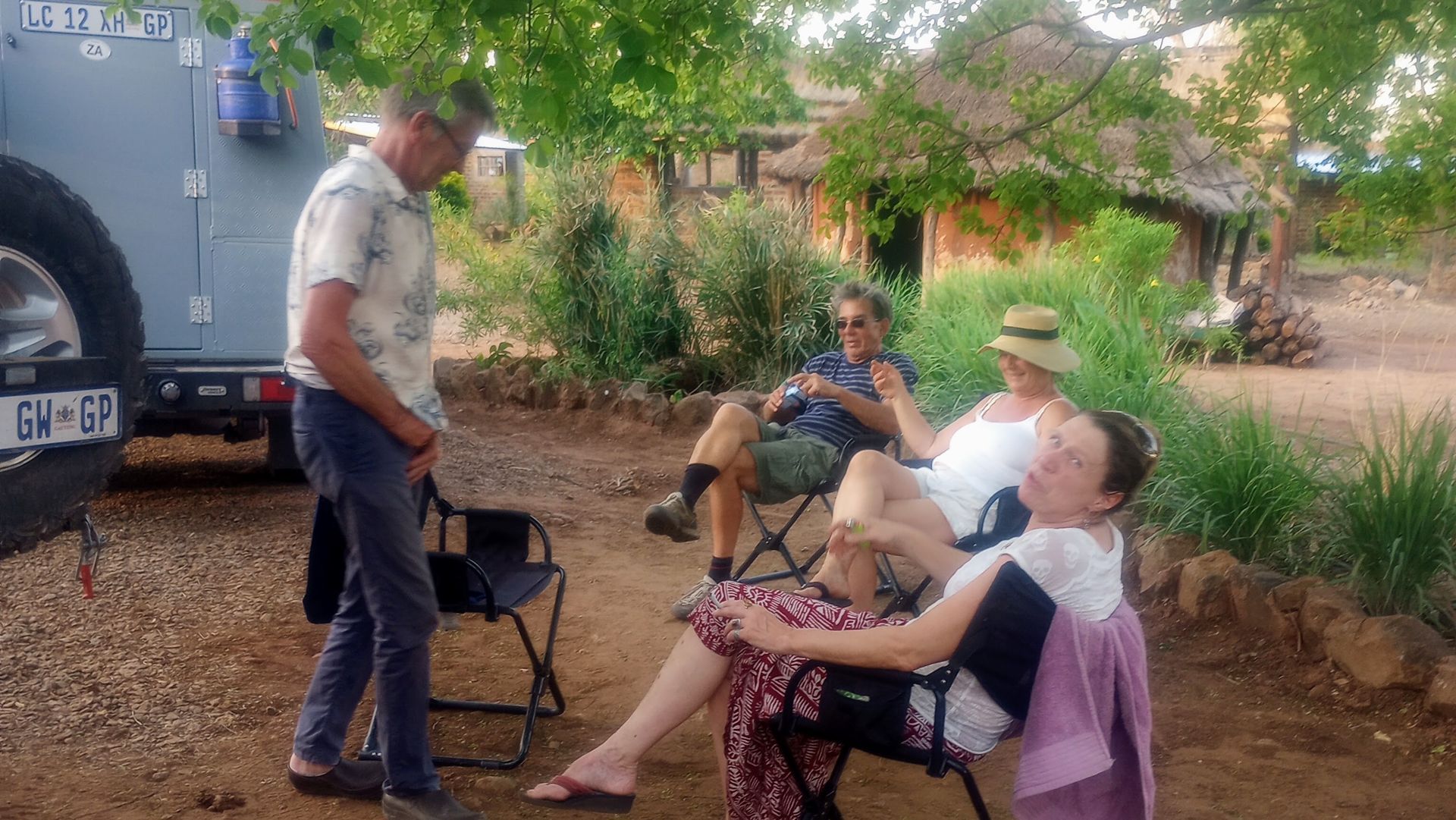 A group of people are sitting in chairs in front of a truck.