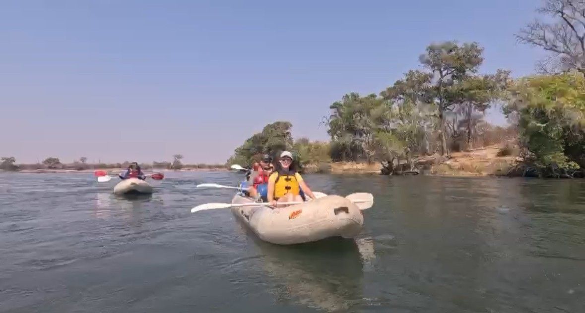 A group of people are riding rafts down a river.