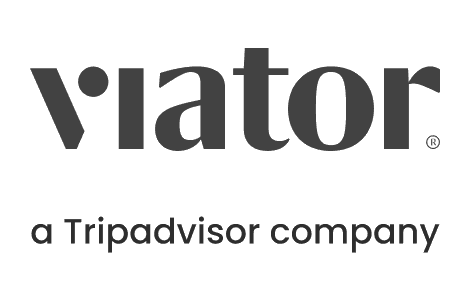 Viator logo, dark gray text with a dot over the "i". "A Tripadvisor company" appears beneath.