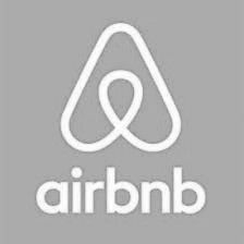 Airbnb logo: white stylized symbol above the word "airbnb" on a gray background.