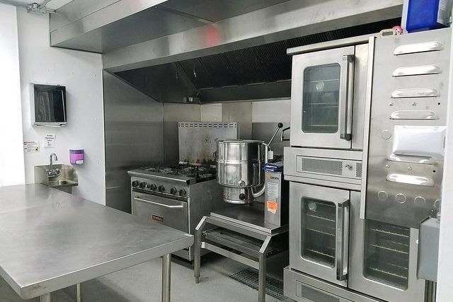 A kitchen with stainless steel appliances and a table.