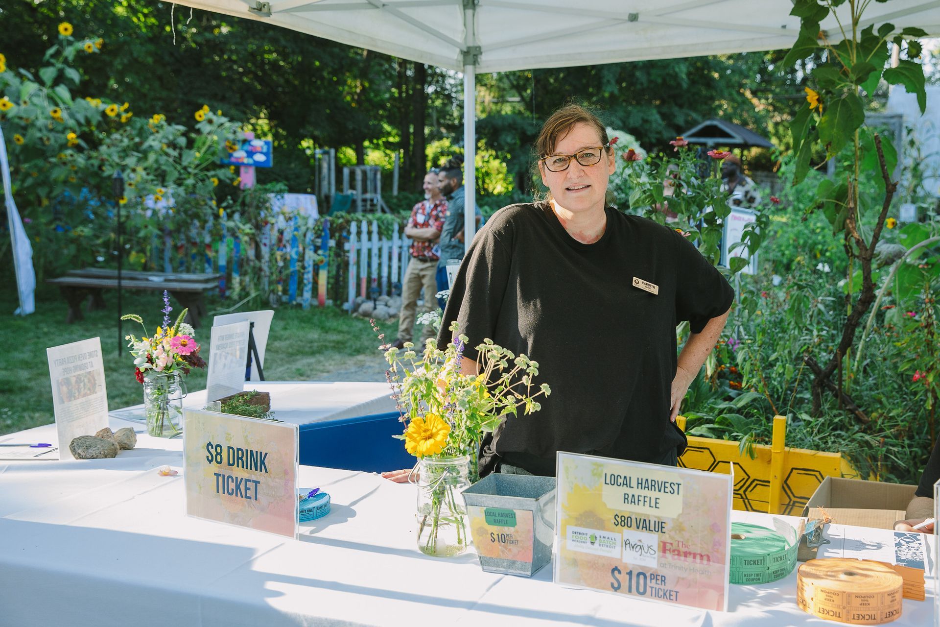 A woman is standing behind a table with a sign that says $ 10