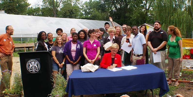 A group of people standing around a table with a podium in the background