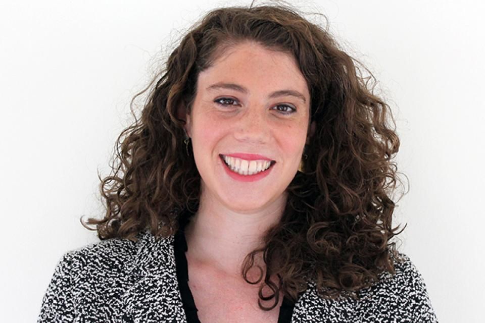 A woman is holding a megaphone and smiling for the camera
