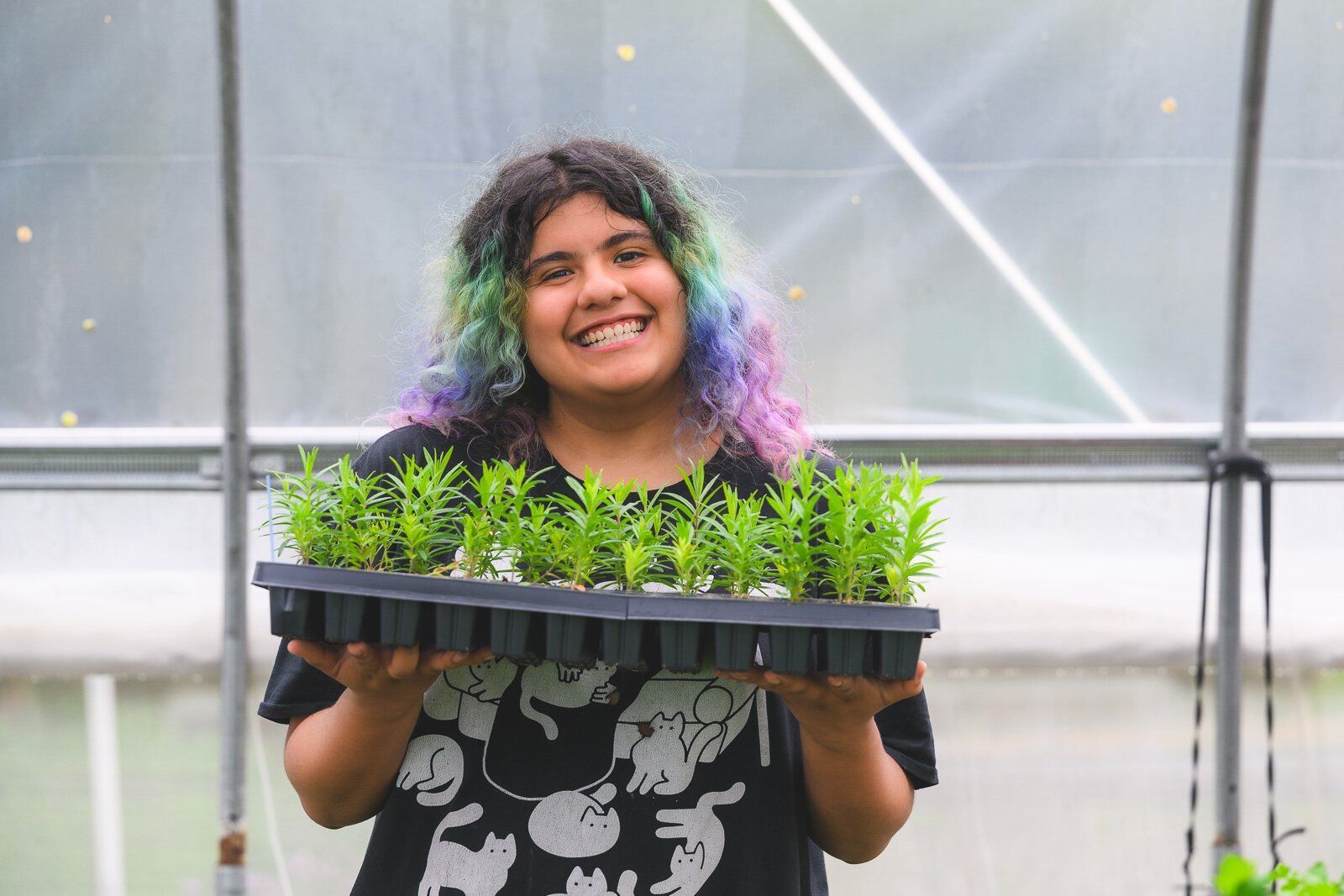 A woman is holding a megaphone and smiling for the camera