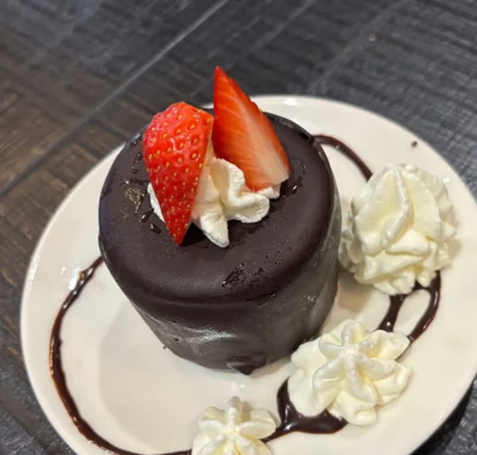 A chocolate cake with whipped cream and strawberries on top
