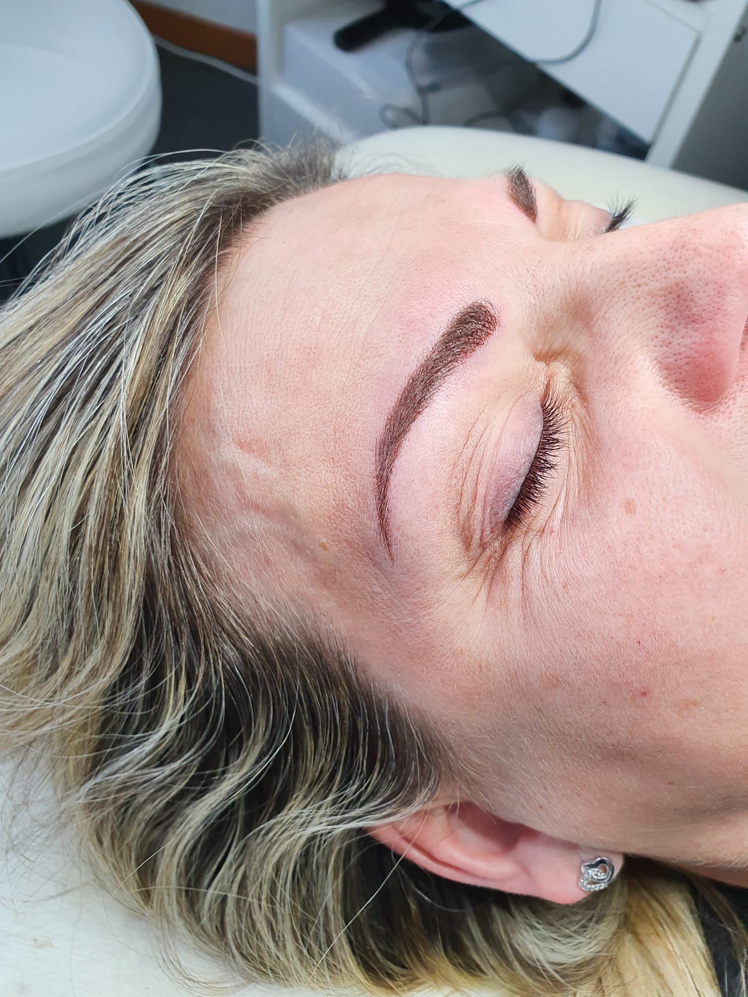 Un primo piano del volto di una donna con gli occhi chiusi.